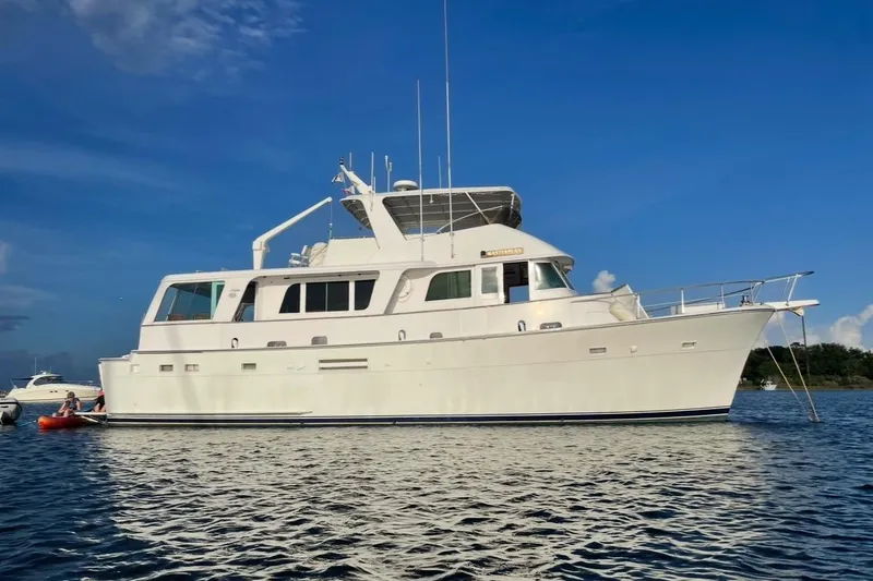 The Image of 1975 Hatteras 58 Long Range Cruiser yacht on calm water under blue sky. - 0