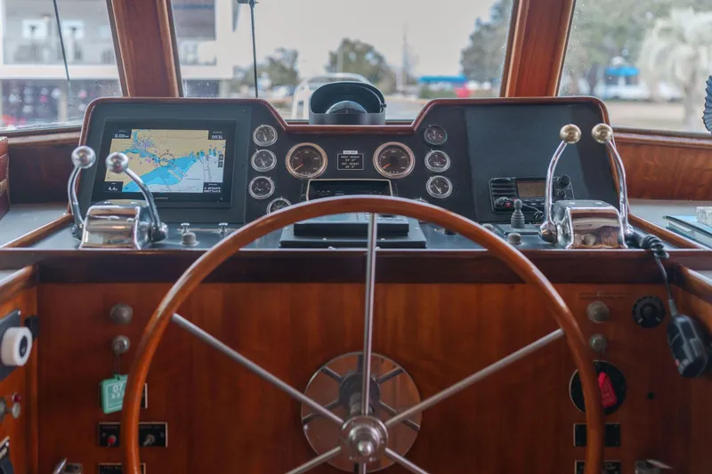 Slide: The Image of 1975 Hatteras 58 Long Range Cruiser helm with navigation equipment and wooden steering wheel. - 7