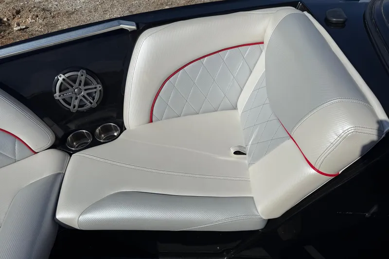Slide: The Image of 2014 MasterCraft X30 boat interior with white and gray seating, red accents, and speaker. - 10