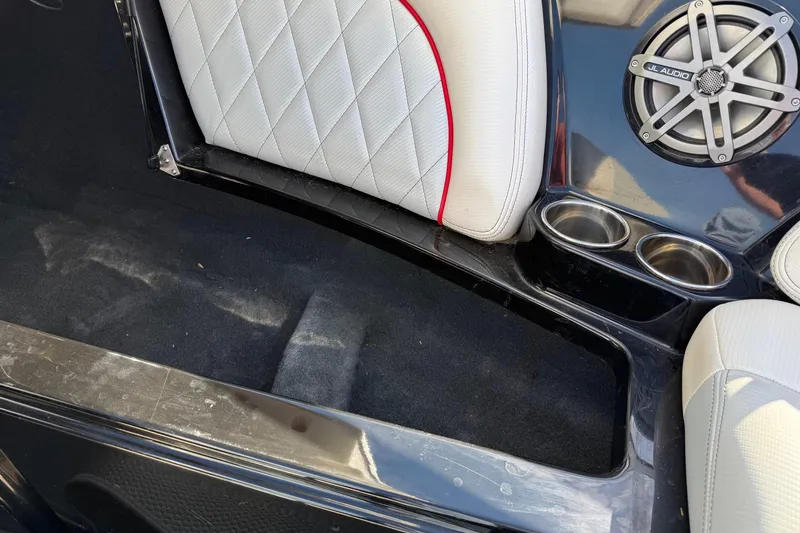 Slide: The Image of 2014 MasterCraft X30 interior with white quilted seats, speaker, and cup holders. - 12