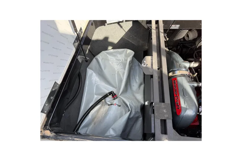 Slide: The Image of 2014 MasterCraft X30 engine compartment with visible components and storage area. - 23