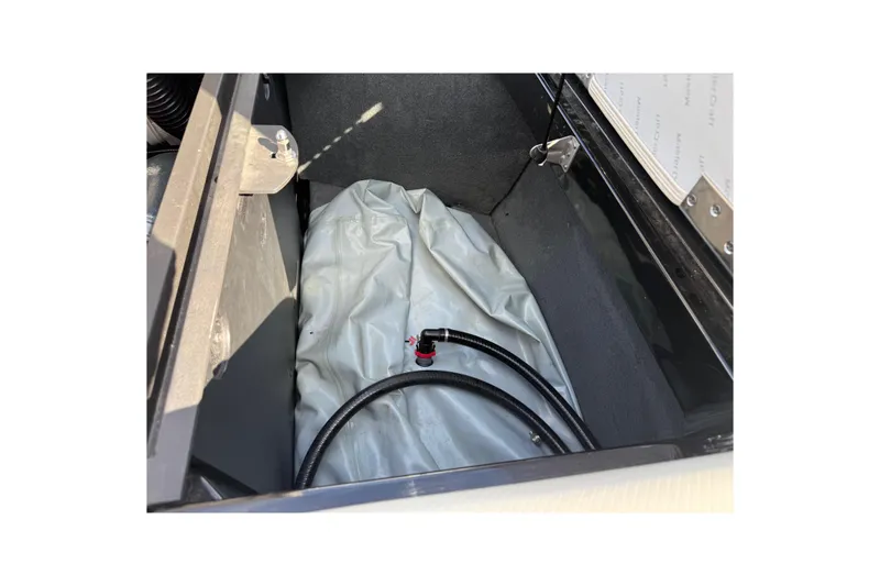 Slide: The Image of 2014 MasterCraft X30 storage compartment with hose and cover. - 24