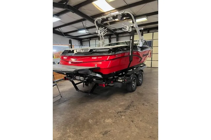 Slide: The Image of 2014 MasterCraft X30 boat in a garage, red exterior, on a trailer. - 30