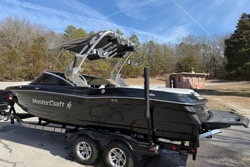 Slide: The Image of 2014 MasterCraft X30 boat on trailer, parked outdoors under clear sky. - 5