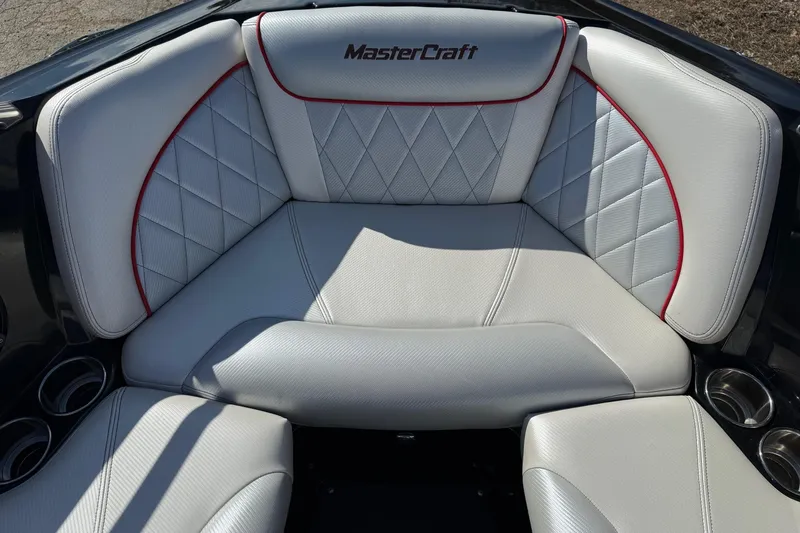 Slide: The Image of 2014 MasterCraft X30 boat interior with white quilted seating and red accents. - 9