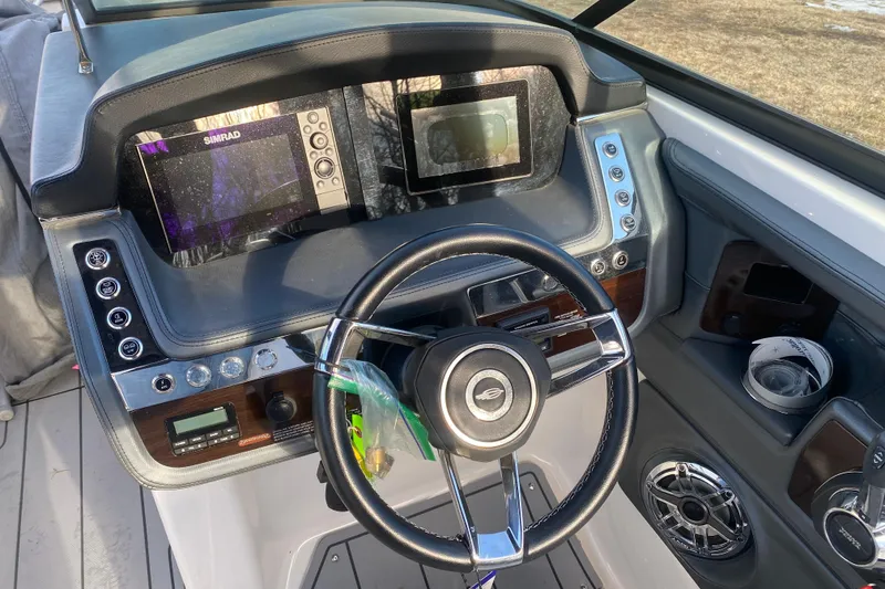 Slide: The Image of 2021 Chaparral 26 Surf boat dashboard with steering wheel and navigation displays. - 4