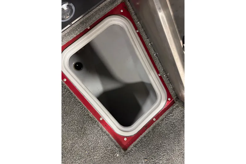 Slide: The Image of 2018 Tracker Pro Guide V-175 Combo boat storage compartment with red trim and gray interior. - 14