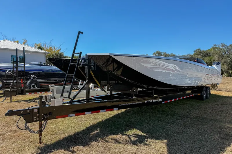 Slide: The Image of 2021 MTI 390X powerboat on trailer, parked on grass under clear blue sky. - 27