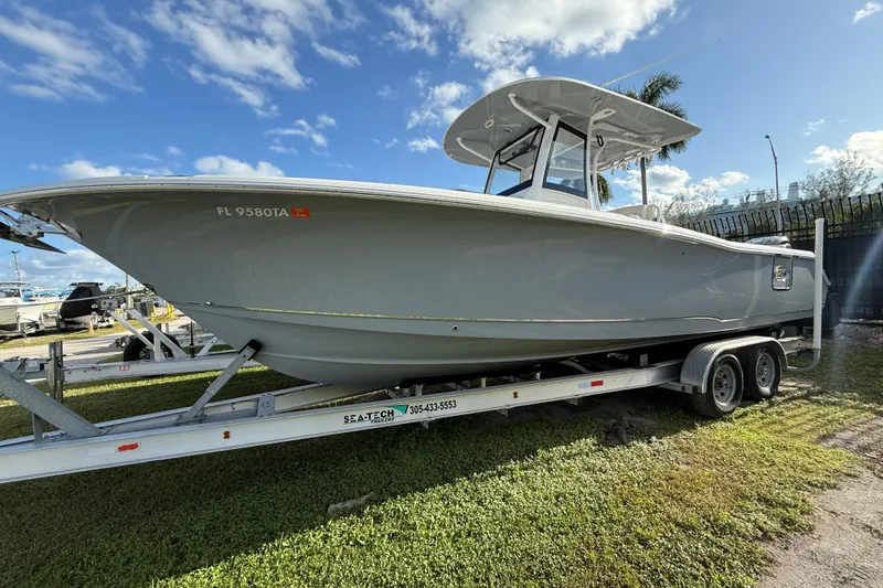 The Image of 2021 Sea Hunt Ultra 305 SE boat on trailer under blue sky. - 0