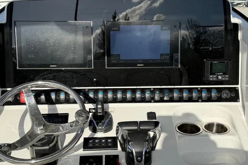 Slide: The Image of Control panel of 2021 Sea Hunt Ultra 305 SE boat with Garmin displays and steering wheel. - 14