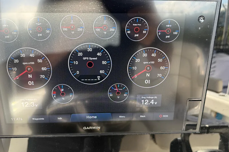 Slide: The Image of 2021 Sea Hunt Ultra 305 SE dashboard with Garmin display showing gauges and engine voltage. - 15