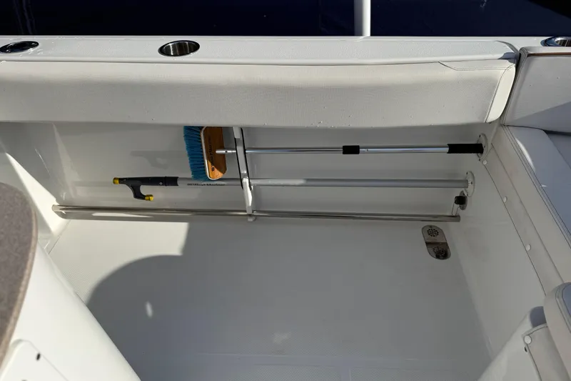 Slide: The Image of Storage compartment on a 2021 Sea Hunt Ultra 305 SE boat with cleaning tools. - 31