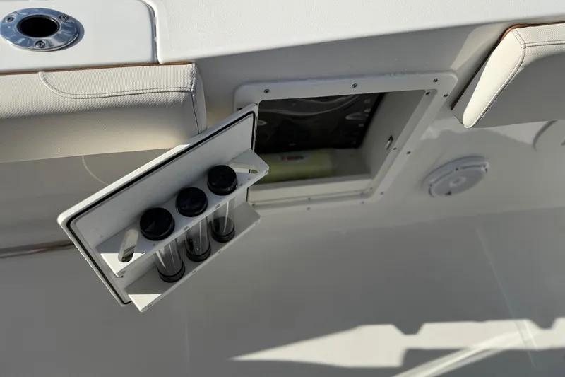 Slide: The Image of 2021 Sea Hunt Ultra 305 SE boat compartment with storage and cup holders. - 38