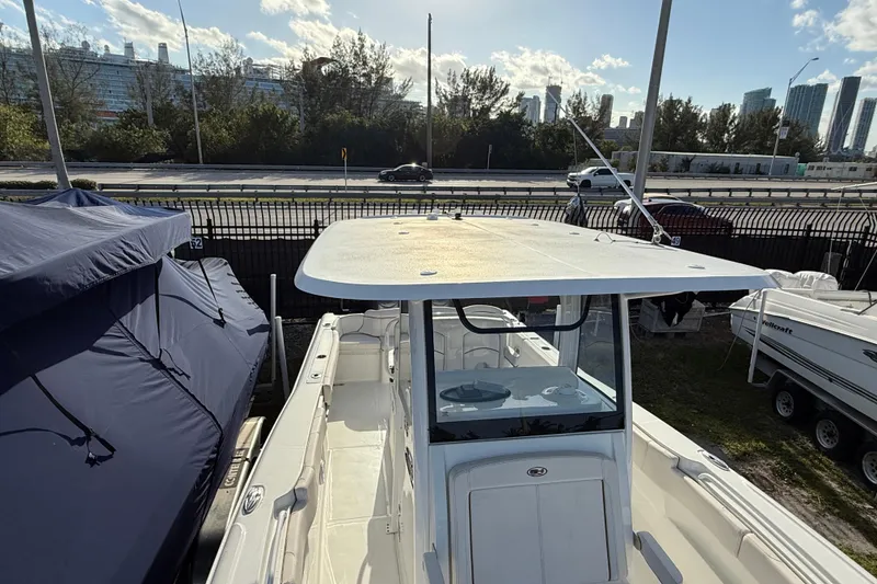 Slide: The Image of 2021 Sea Hunt Ultra 305 SE boat docked, showcasing spacious deck and modern design. - 6