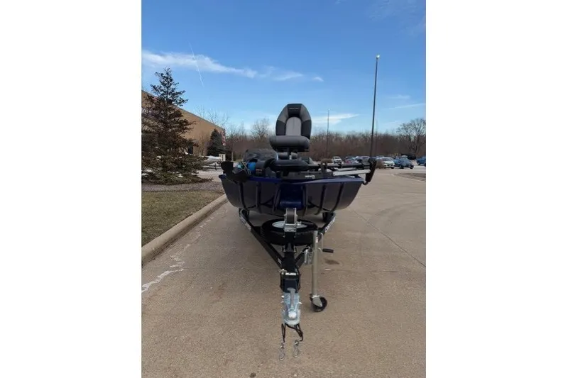 Slide: The Image of 2021 Crestliner 1700 Storm boat on trailer in parking lot, clear sky background. - 2