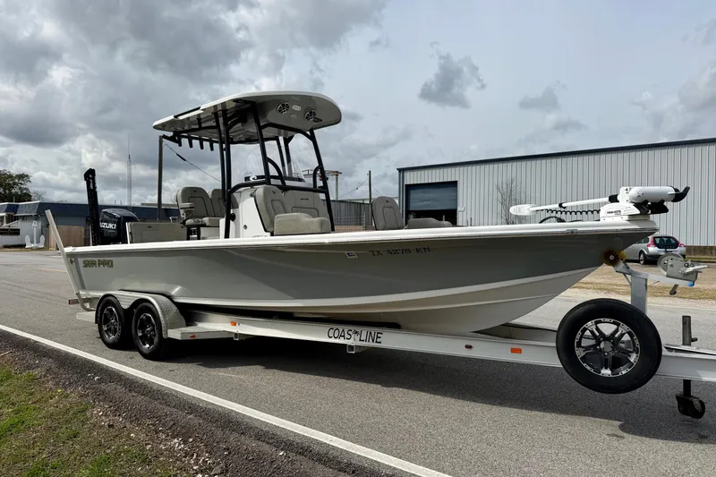 Slide: The Image of 2021 Sea Pro 248 Bay boat on trailer, parked outdoors under cloudy sky. - 5