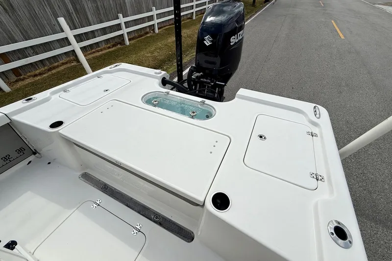 Slide: The Image of 2021 Sea Pro 248 Bay boat with Suzuki outboard motor, white deck, and storage compartments. - 8