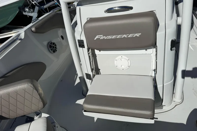 Slide: The Image of 2022 Finseeker 230 CC boat interior with cushioned seating and speaker detail. - 18
