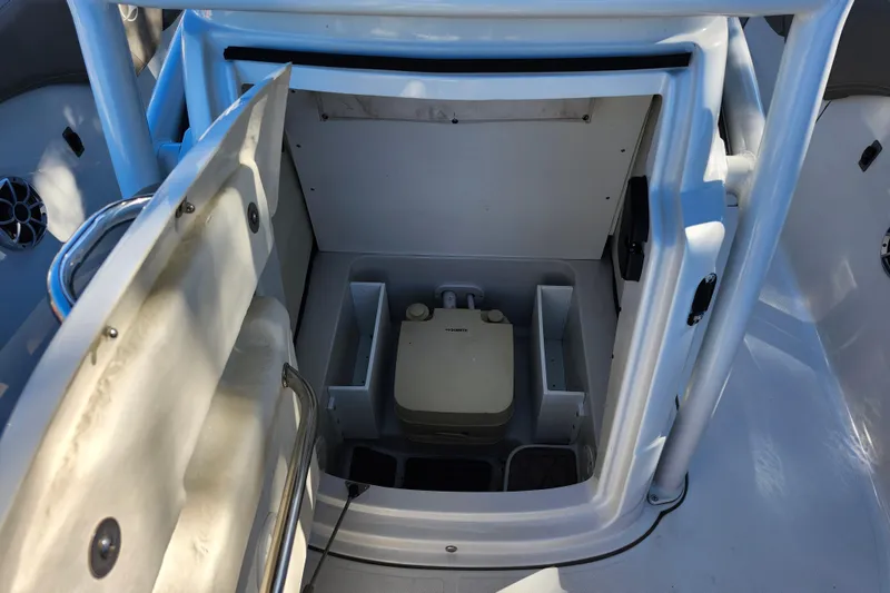 Slide: The Image of 2022 Finseeker 230 CC boat interior with storage compartment and portable toilet. - 19