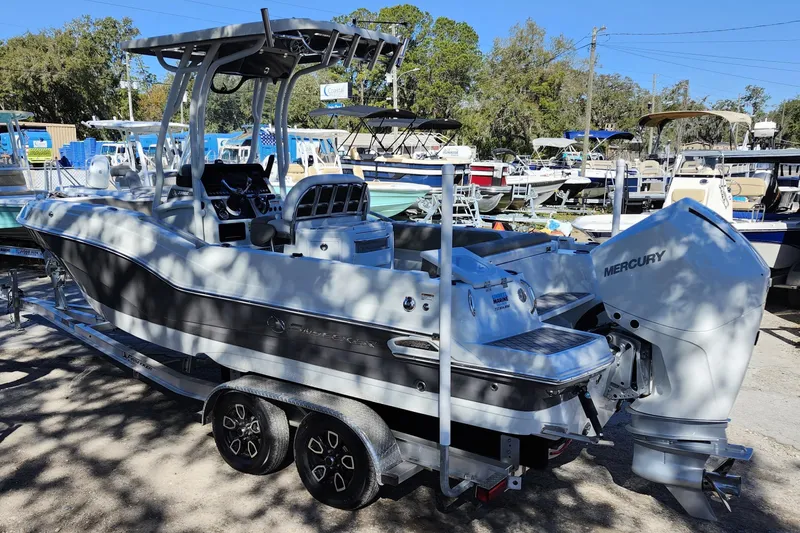Slide: The Image of 2022 Finseeker 230 CC boat with Mercury engine on trailer in marina setting. - 2