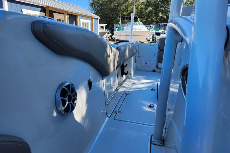 Slide: The Image of 2022 Finseeker 230 CC boat interior with seating and speaker, docked outdoors. - 22