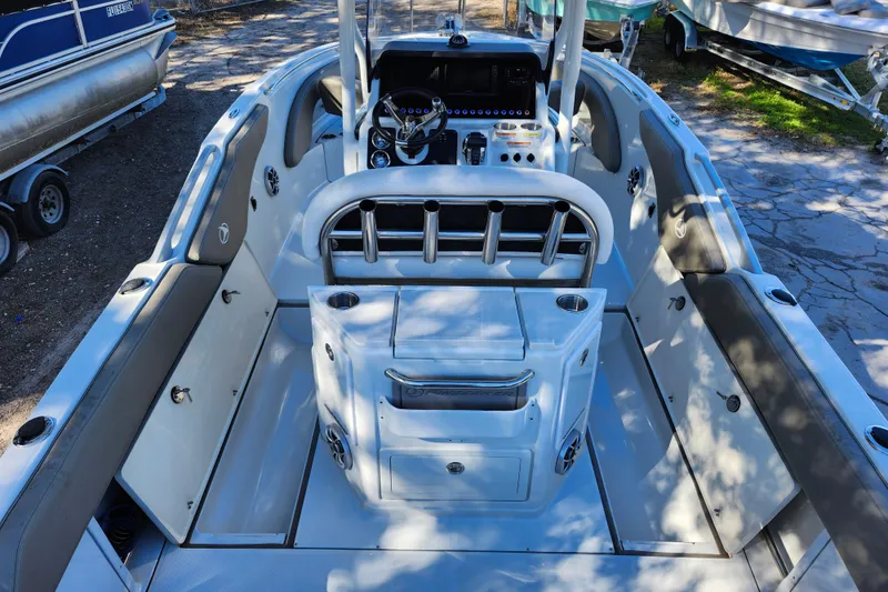 Slide: The Image of 2022 Finseeker 230 CC boat interior with console and seating, docked outdoors. - 23