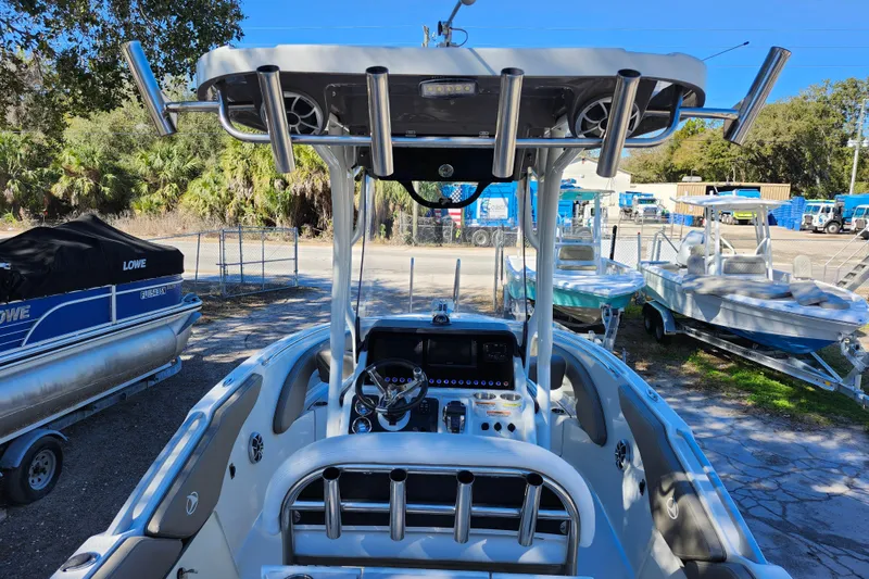 Slide: The Image of 2022 Finseeker 230 CC boat with center console and rod holders, parked outdoors. - 24