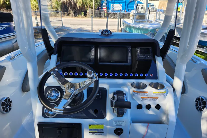 Slide: The Image of 2022 Finseeker 230 CC boat dashboard with steering wheel and navigation controls. - 31