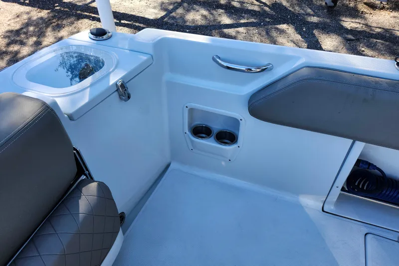 Slide: The Image of 2022 Finseeker 230 CC boat interior with seating, cup holders, and storage. - 37