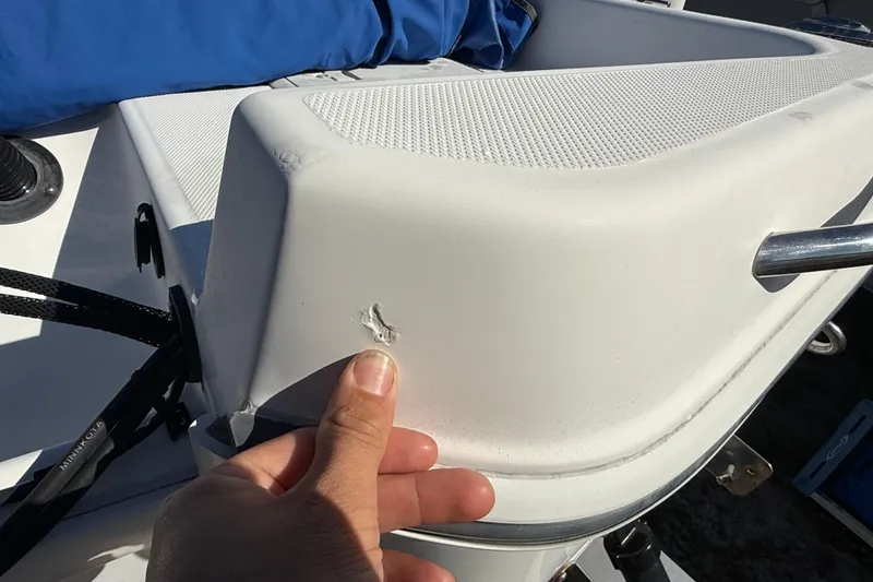 Slide: The Image of 2002 Cobia 191 Bay boat with minor hull damage, close-up view. - 17