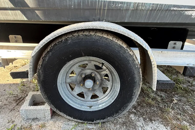 Slide: The Image of Trailer wheel of a 2002 Cobia 191 Bay boat on a concrete block. - 18