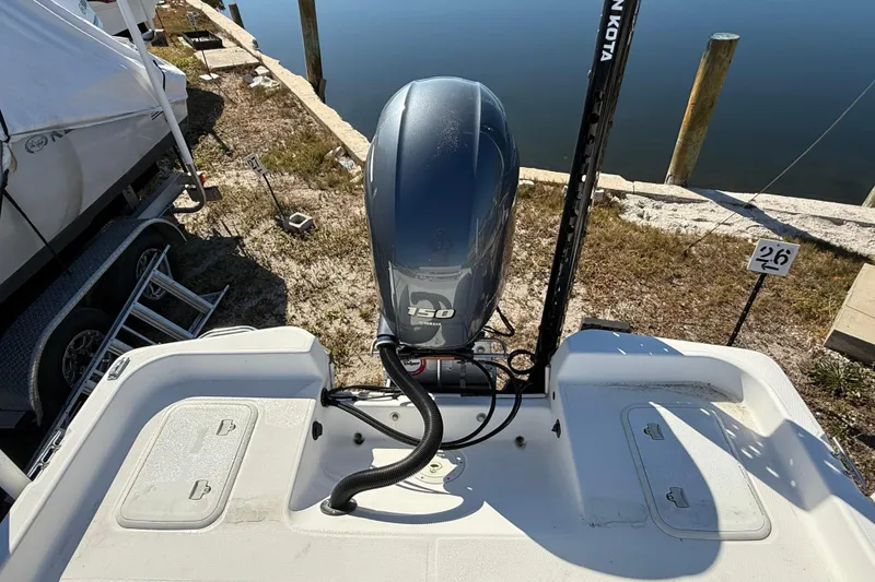Slide: The Image of 2002 Cobia 191 Bay boat with 150 HP outboard motor, docked near water. - 21