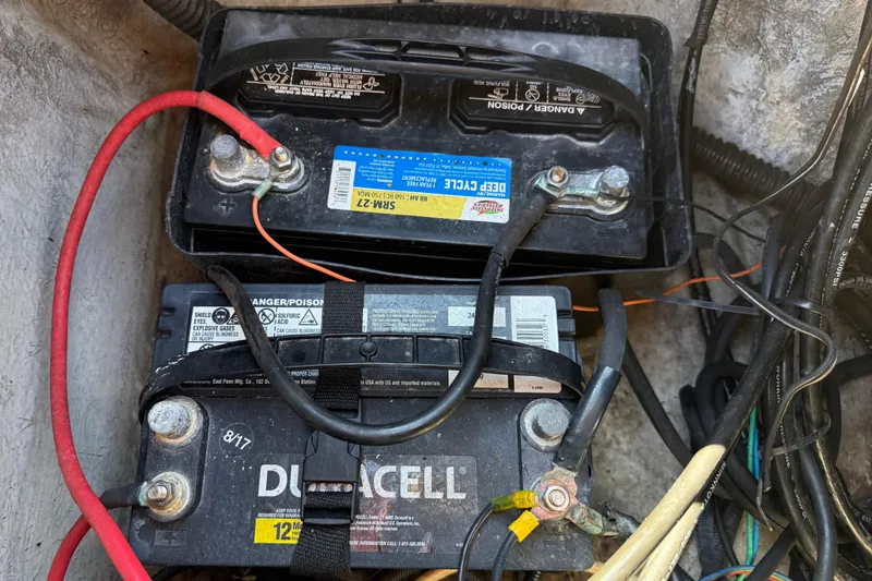 Slide: The Image of Two marine batteries in a 2002 Cobia 191 Bay boat, connected with cables. - 23
