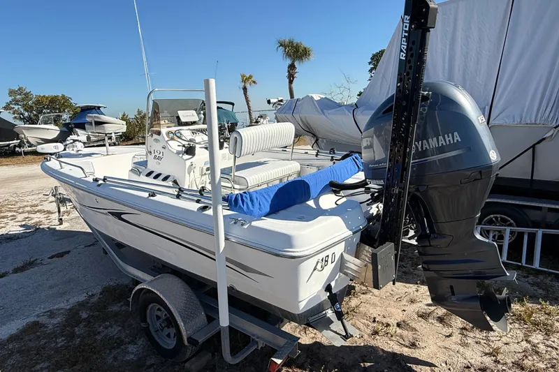 Slide: The Image of 2002 Cobia 191 Bay boat with Yamaha motor on trailer, parked outdoors. - 3