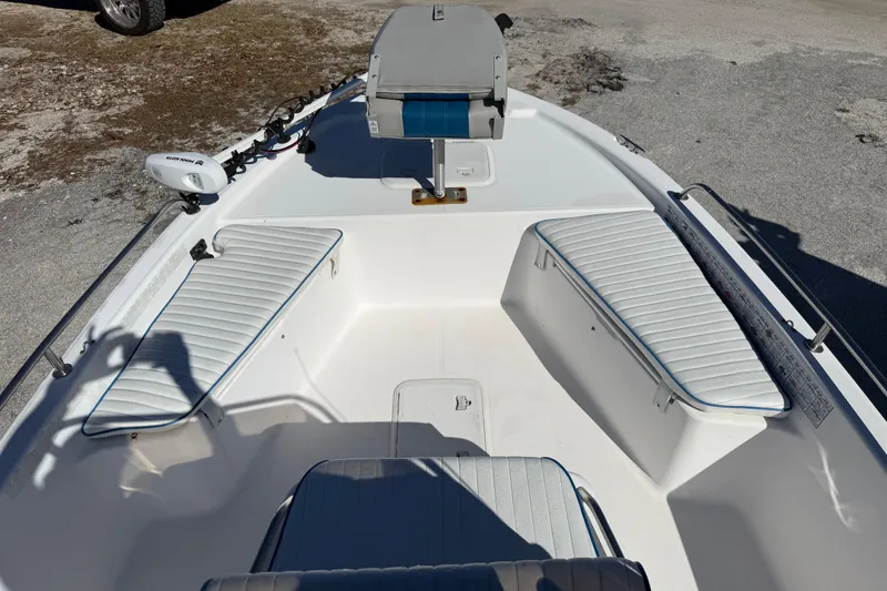 Slide: The Image of 2002 Cobia 191 Bay boat interior with white seating and steering console. - 34