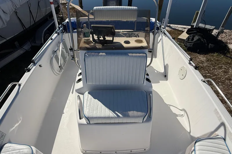 Slide: The Image of 2002 Cobia 191 Bay boat interior with seating and console, docked outdoors. - 35