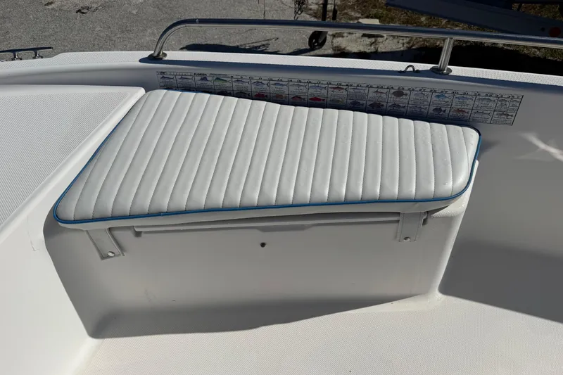 Slide: The Image of 2002 Cobia 191 Bay boat seat with white cushioned upholstery and fish identification chart. - 37