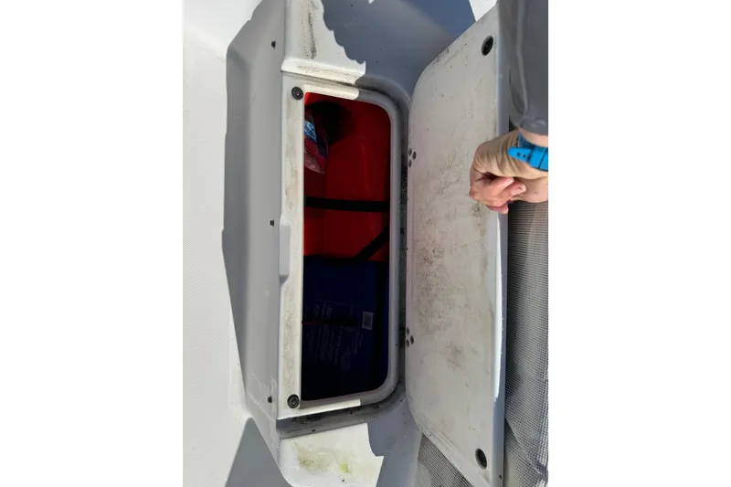 Slide: The Image of Open storage compartment on 2002 Cobia 191 Bay boat, showing interior contents. - 38