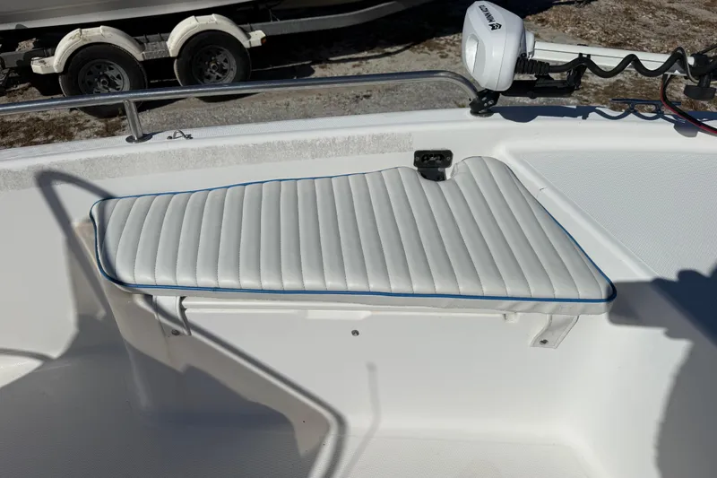 Slide: The Image of 2002 Cobia 191 Bay boat with white cushioned seating and trolling motor. - 39