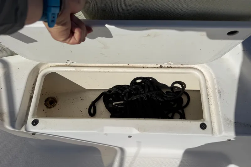 Slide: The Image of Open storage compartment on 2002 Cobia 191 Bay boat with coiled black rope inside. - 40