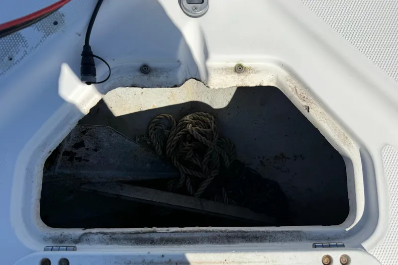 Slide: The Image of Open storage compartment on 2002 Cobia 191 Bay boat with rope and anchor. - 43