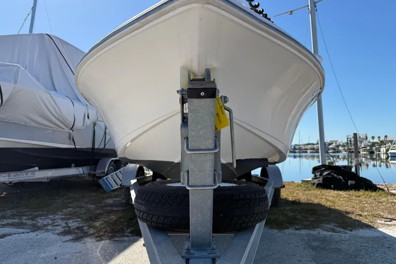 Slide: The Image of 2002 Cobia 191 Bay boat on trailer at marina, clear sky background. - 6