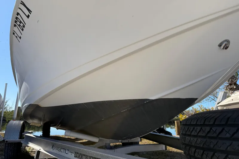 Slide: The Image of 2002 Cobia 191 Bay boat on trailer, close-up of hull and tire. - 7