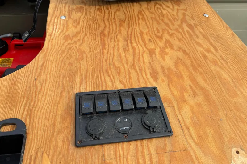 Slide: The Image of Control panel on wooden surface of 2025 Tracker Grizzly 1542 Utility boat. - 10