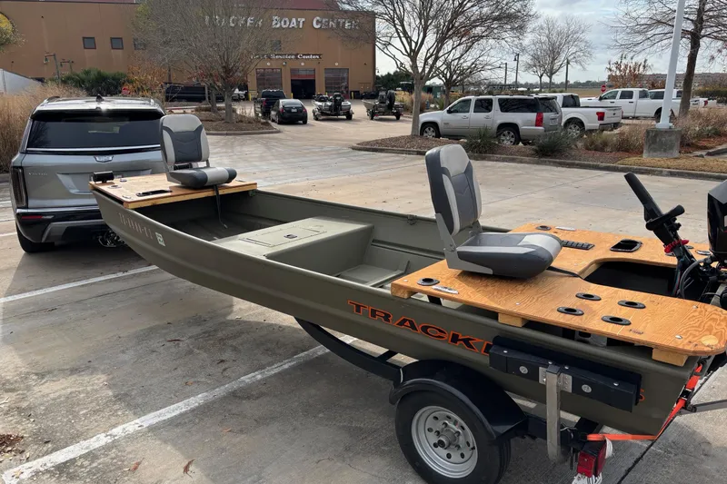Slide: The Image of 2025 Tracker Grizzly 1542 Utility boat on trailer in parking lot. - 2