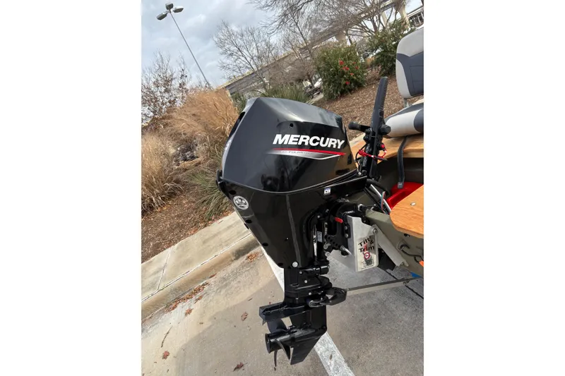 Slide: The Image of 2025 Tracker Grizzly 1542 Utility boat with Mercury outboard motor in a parking lot. - 8