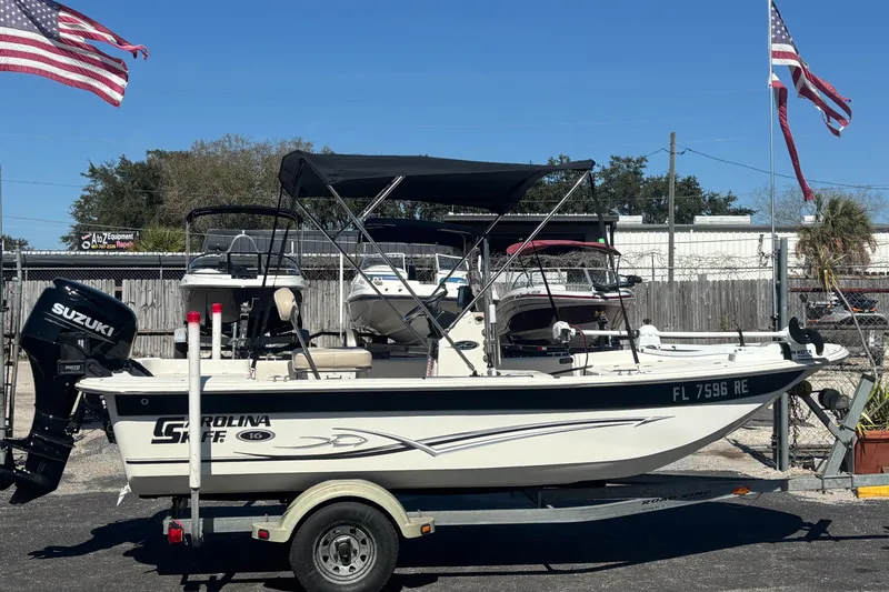 The Image of 2016 Carolina Skiff 16 JVX CC boat on trailer with Suzuki outboard motor. - 0