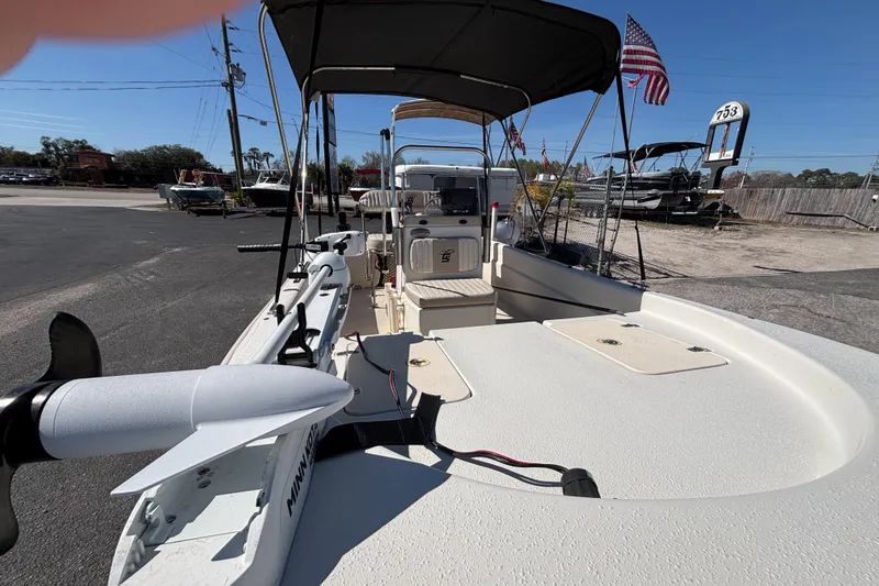 Slide: The Image of 2016 Carolina Skiff 16 JVX CC boat with canopy and trolling motor in a parking lot. - 17