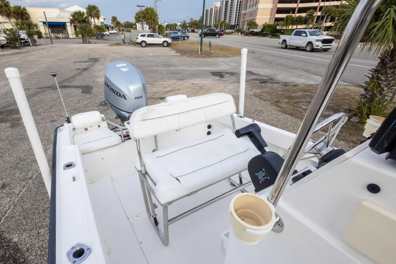 Slide: The Image of 1999 Boston Whaler Outrage 17 boat with Honda 150 engine, parked near a road. - 19