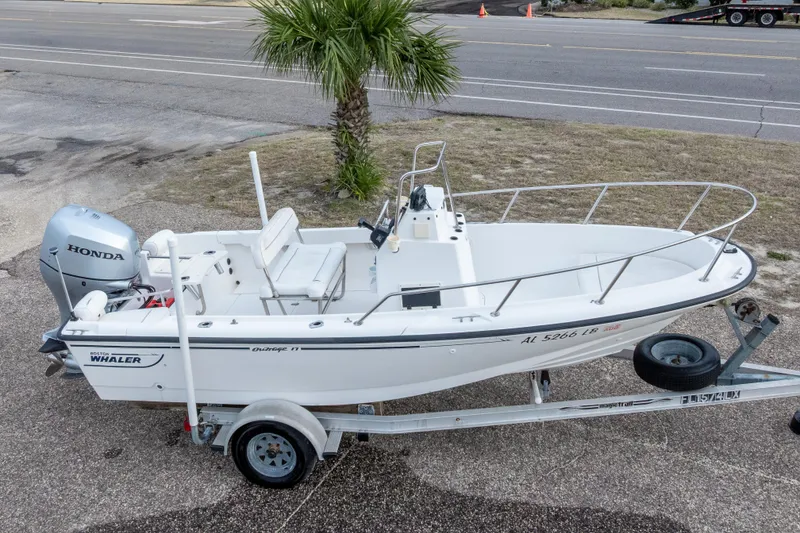 Slide: The Image of 1999 Boston Whaler Outrage 17 boat on trailer with Honda outboard motor. - 2